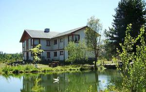 une grande maison avec un lac en face de celle-ci dans l'établissement Complejo Turístico Sol de Puelo, à Lago Puelo