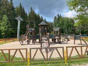 a park with a playground with a play equipment at Apartmán Resident A001 - BEZBARIÉROVÝ Apartmán ideální pro rodiny s dětmi, v těsné blízkosti Anenského údolí, bobové dráhy, Ski areálů, Ski školy, FREE PARKING, FREE WIFI, výhled do zahrady s posezením na terase, dětské hřiště v areálu in Harrachov