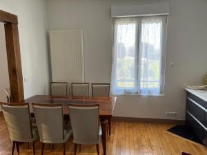 ein Esszimmer mit einem Holztisch und Stühlen in der Unterkunft La maison de la brasserie in Sens