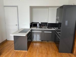 eine Küche mit weißen Schränken und einer Arbeitsplatte in der Unterkunft La maison de la brasserie in Sens