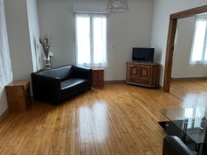 ein Wohnzimmer mit einem schwarzen Ledersessel und einem TV in der Unterkunft La maison de la brasserie in Sens + 5 Fotos