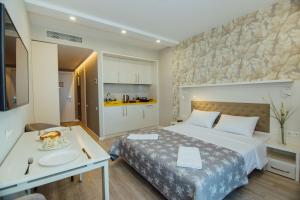 a hotel room with a bed and a kitchen at Sunshine Apartments Batumi in Batumi +60 photos