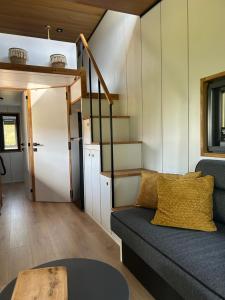 a living room with a couch and a staircase at Tiny House Ti Nid 4 étoiles in Montain