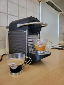 a coffee maker with two cups on a counter at SunsetApartment in Siviri +12 photos