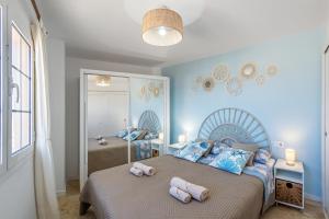 a bedroom with a bed with two towels on it at Casita Azul Las Arenas in Caleta De Fuste