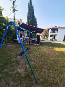 a swing set with a canopy in a yard at GeoVilla Green & Blue 2 - Pefkochori in Pefkochori