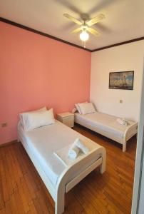 two beds in a room with orange walls at GeoVilla Green & Blue 2 - Pefkochori in Pefkochori