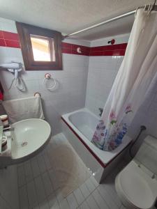 a bathroom with a tub and a toilet and a sink at GeoVilla Green & Blue 2 - Pefkochori in Pefkochori