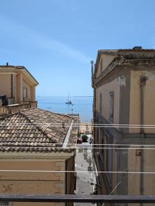 a view of the ocean from between two buildings at MeryTes - Casa vista mare in Crotone