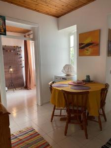 einen Esstisch mit einem gelben Tischtuch darauf in der Unterkunft Villa Atlantica Apartments in Angra do Heroísmo