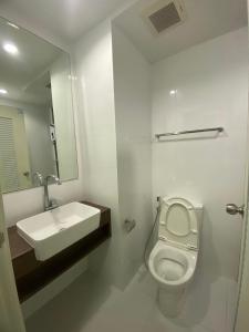 a bathroom with a sink and a toilet and a mirror at Mari Space in Nonthaburi