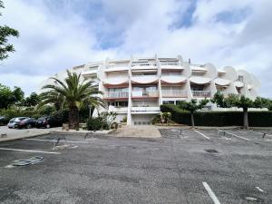 un parking devant un immeuble dans l'établissement Studio cabine moderne design avec vu sur jardin , piscine, à La Grande Motte