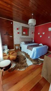 a bedroom with a bed in a room with red walls at Pousada Requinte Serrano in Urubici