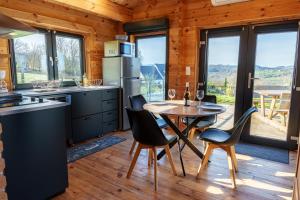 a kitchen and dining room with a table and chairs at Le Chalet du Crescent in Saint-Germain-des-Champs