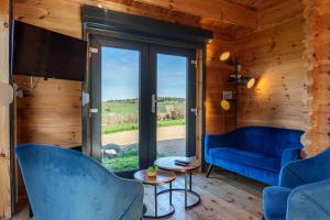 a living room with blue furniture and a large window at Le Chalet du Crescent in Saint-Germain-des-Champs +32 photos