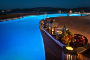 a bowl of fruit on the edge of a swimming pool at Aethos Sardinia in Cannigione