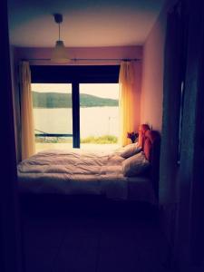 a bedroom with a bed and a large window at Ravishing View, Zastani Houses in Marmari +29 photos