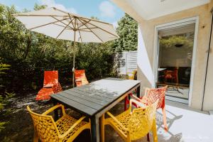 un tavolo e sedie con un ombrellone in un patio di Domaine des Bains a Vals-les-Bains