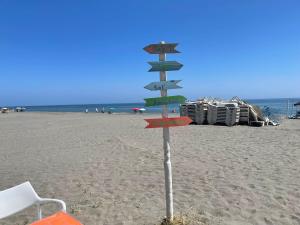 a directional sign on the beach with a chair at Laguna Green Apartment in Torrox Costa +26 photos