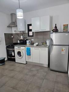 une cuisine avec un réfrigérateur et une machine à laver dans l'établissement El Legado Departamento, à San Juan