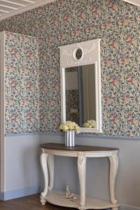 a mirror and a table in a room with wallpaper at Dorion Hotel in Ornos