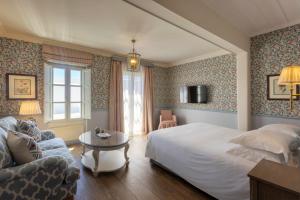 a bedroom with a bed and a couch and a table at Dorion Hotel in Ornos