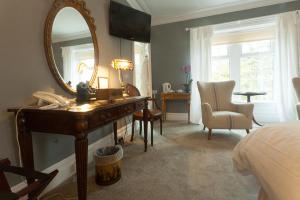 a bedroom with a desk and a mirror and a bed at Meifod House in Caernarfon