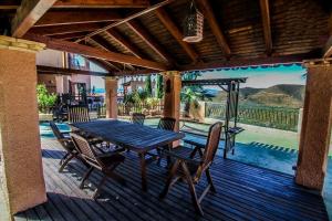 ein Holztisch und Stühle auf einer Holzterrasse in der Unterkunft Casa Disa in Turre