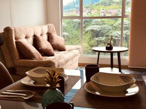 a living room with a couch and a table at Espectacular vista, apto de lujo, piscina, gym in Manizales
