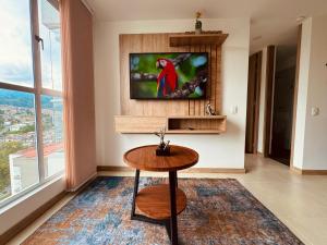 a living room with a table and a tv at Espectacular vista, apto de lujo, piscina, gym in Manizales