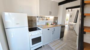 a kitchen with white appliances and a white refrigerator at Apartment Max in Borovići +55 photos