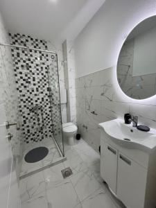 a white bathroom with a shower and a sink at Vila Sunset in Soko Banja +141 photos