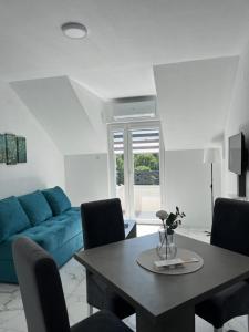 a living room with a blue couch and a table at Vila Sunset in Soko Banja