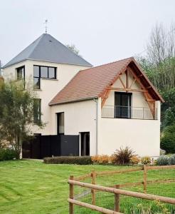 a white house with a fence in a field at Maison moderne du Perche - Bienvenue chez Aurélie in Laleu