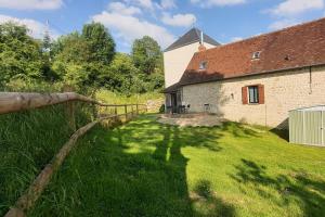 a house with a fence and a grass yard at Maison moderne du Perche - Bienvenue chez Aurélie in Laleu
