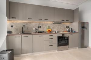 a kitchen with white cabinets and stainless steel appliances at Luxurious Coastal Retreat in Central Glyfada in Athens