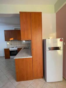 a kitchen with a white refrigerator and wooden cabinets at Spacious Quiet Apartment for Relaxed Holidays 2 in Kriezá +10 photos