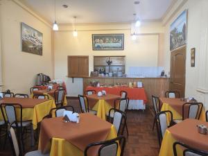 a restaurant with tables with yellow and orange table cloth at HOTEL WENDY MAR in Copacabana