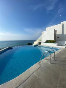a swimming pool with the ocean in the background at OceanSmart, comodidad inteligente frente al mar in Manta