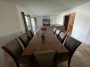 una mesa de madera con sillas y un jarrón en la parte superior en Casa Marina Turquesa 16 Personas, en Mazatlán