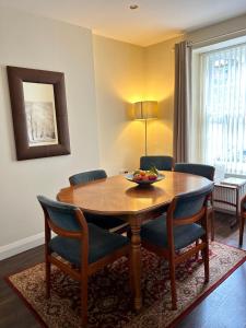 ein Esszimmer mit einem Holztisch und Stühlen in der Unterkunft Wee Betty’s Cottage in Caledon