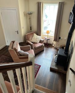 ein Wohnzimmer mit einem Sofa und einem Holzofen in der Unterkunft Wee Betty’s Cottage in Caledon