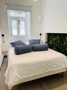 a bed with blue pillows on it in a room at Butera Apartments Luxury in Palermo