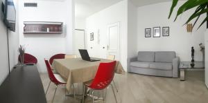 une salle à manger avec une table avec des chaises rouges et un ordinateur portable dans l'établissement Machiavelli House - Intero appartamento Cagliari, à Cagliari