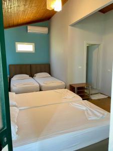 a room with three beds in a room at Chalet Ambel in Dhërmi