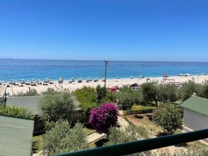 a view of a beach with chairs and umbrellas at Chalet Ambel in Dhërmi