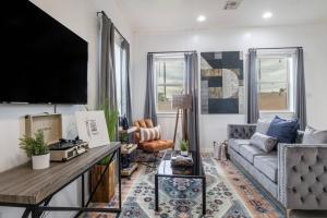 a living room with a couch and a flat screen tv at Vibrant Gray Downtown Loft in New Orleans