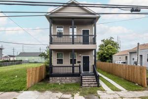 a house with a balcony and a fence at Vibrant Gray Downtown Loft in New Orleans