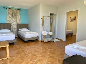 a bedroom with two beds and a tiled floor at Chalet Ambel in Dhërmi