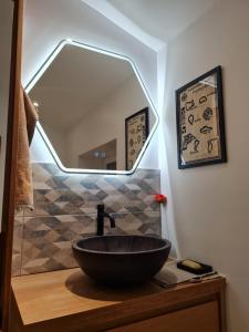 ein Badezimmer mit einem schwarzen Waschbecken und einem Spiegel in der Unterkunft Artist house with piano and charming garden in Reims + 32 Fotos